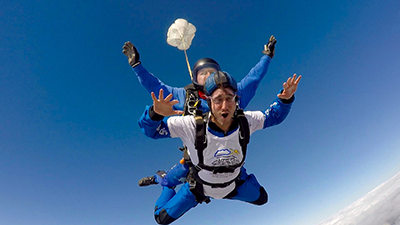 Free fall skydiving tiny little parachute moving cheeks
