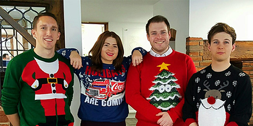 4 people lines up wearing christmas jumpers