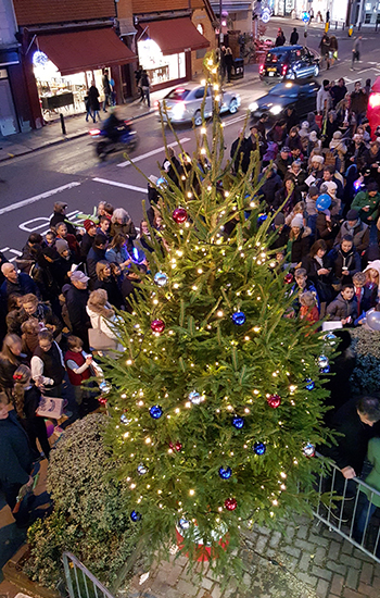 real Christmas tree with loads of people outside around it 