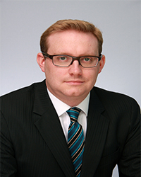 ginger man with a suit on and glasses