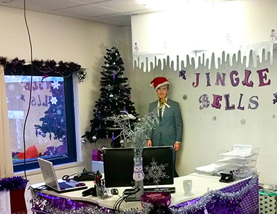 office covered in Christmas desecration with a cut out in the cornerwith a Christmas hat on 