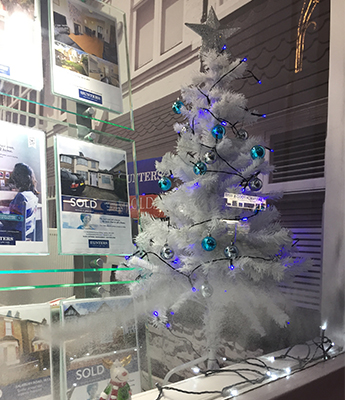 inside a estate-agent  office with Christmas tree