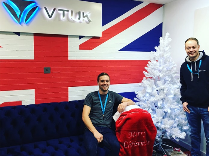 British flag on the wall with 2 men in the room