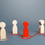 Wooden figures representing leadership and team connection in real estate.