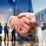 Business handshake symbolising trust and successful property transactions in a bustling city environ.